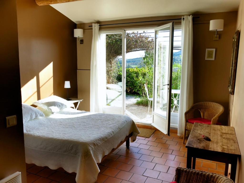 穆斯捷-圣玛丽Les Oliviers的一间卧室设有一张床和一个滑动玻璃门