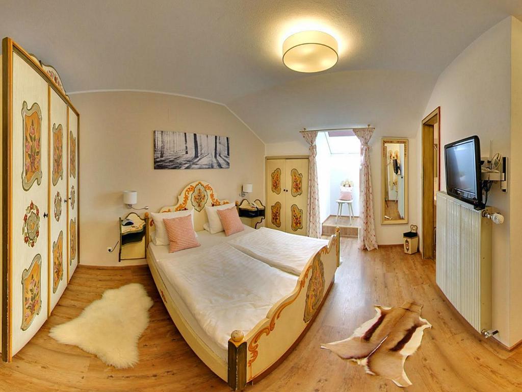 基姆湖畔贝尔瑙阿尔特维特酒店的一间卧室配有一张大床和一台平面电视