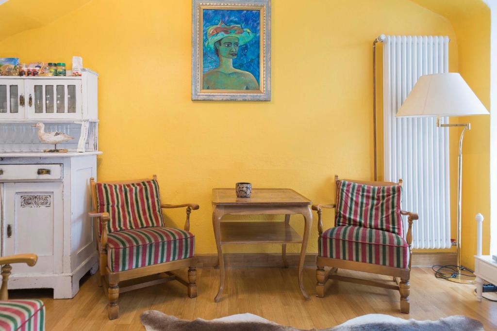 康斯坦茨Haus zum Einhörnle的客厅配有两把椅子、一张桌子和一幅画