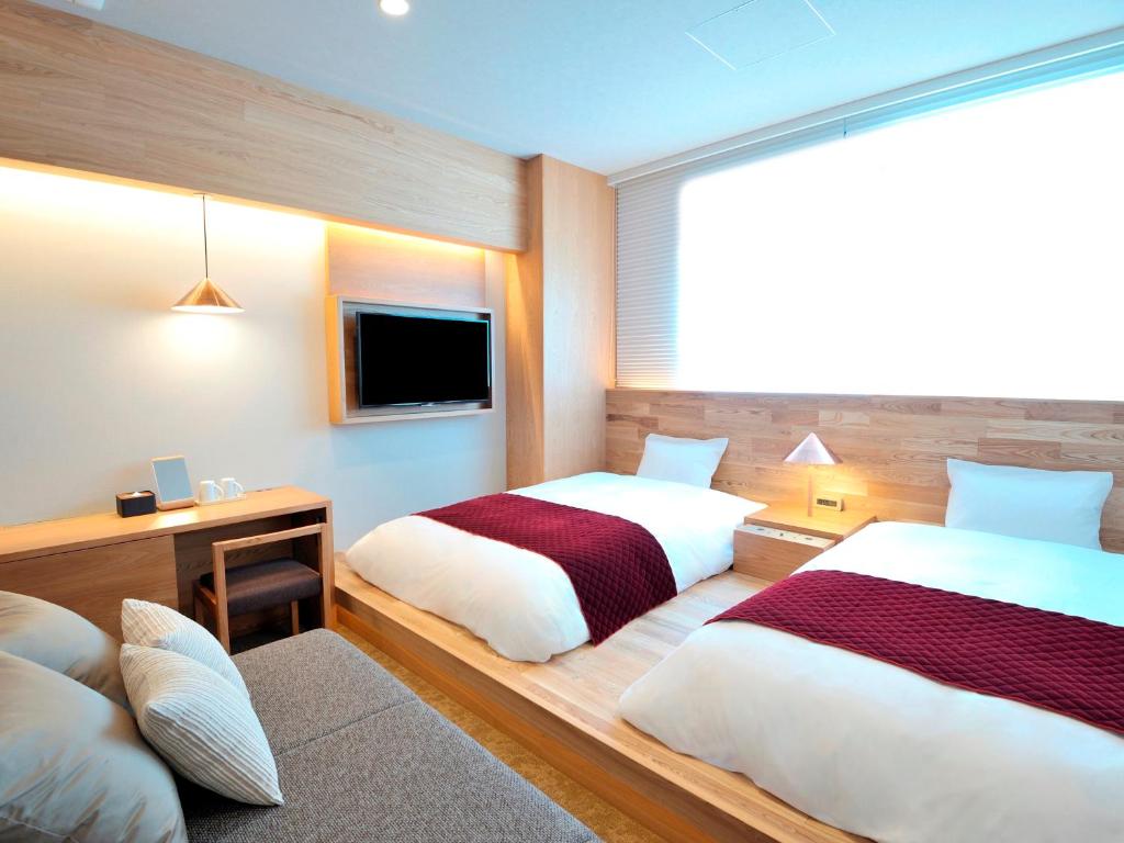 大阪大阪本町酒店的一间酒店客房,设有两张床和电视