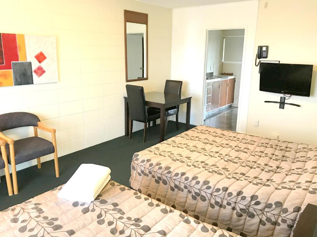 罗托鲁瓦Greenview Motel的酒店客房设有两张床、一张桌子和电视。
