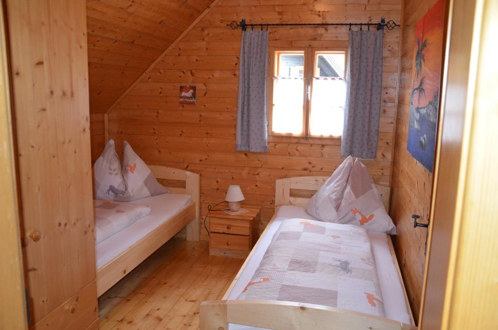 多内尔斯巴赫瓦尔德Ferienhaus Anna的小木屋内一间卧室,配有两张床