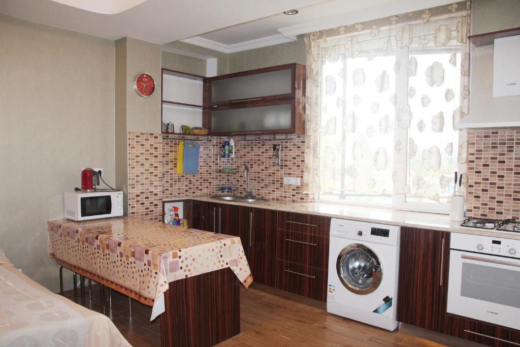 乌雷基Apartment near the Black Sea Ureki的厨房配有桌子和洗衣机。