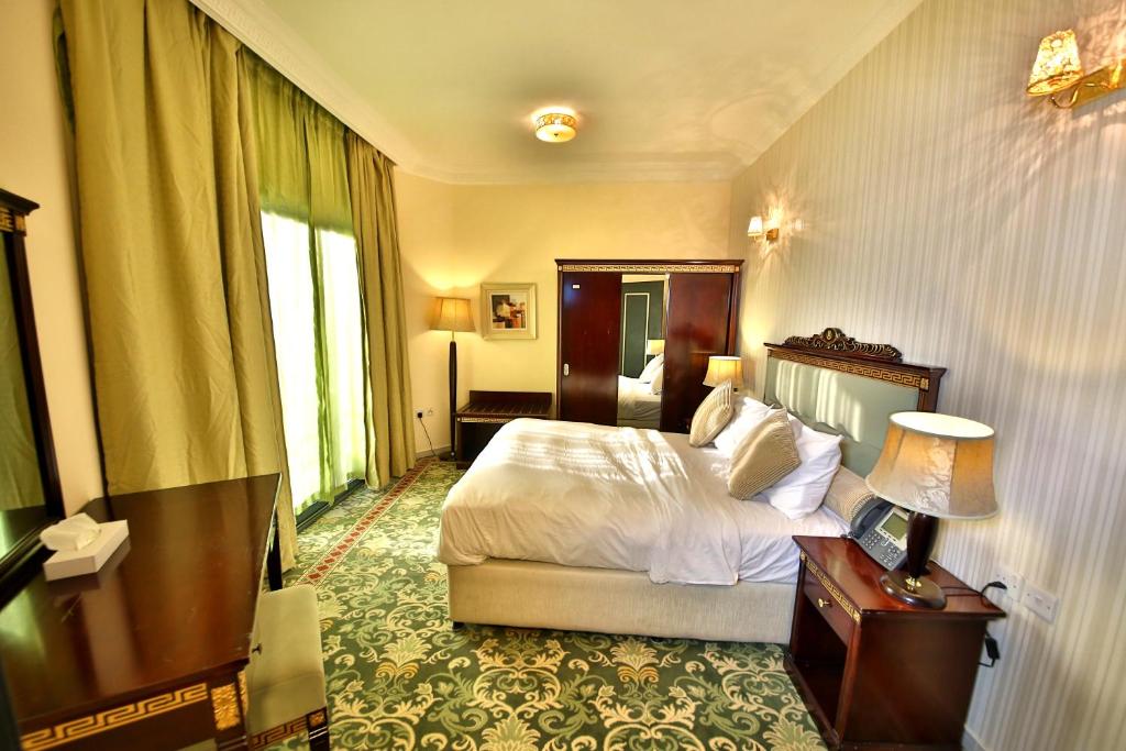 阿吉曼中城家具公寓的一间卧室配有一张床、一张桌子和一盏灯