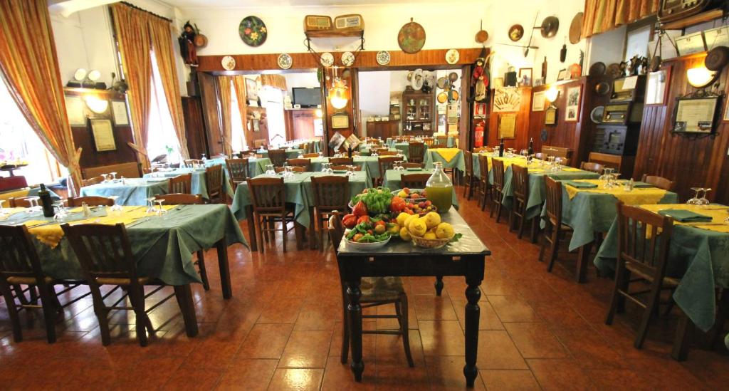 Molini di TrioraAlbergo Santo Spirito的餐厅设有桌椅,餐桌上摆放着水果