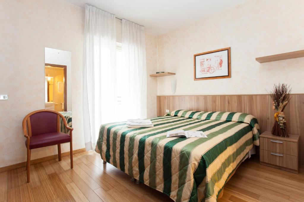 米兰德赛莎诺住宅酒店的配有一张床和一把椅子的酒店客房