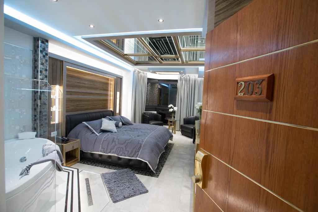 朱尼耶卡米洛特酒店的一间卧室配有一张床、一个浴缸和一个水槽