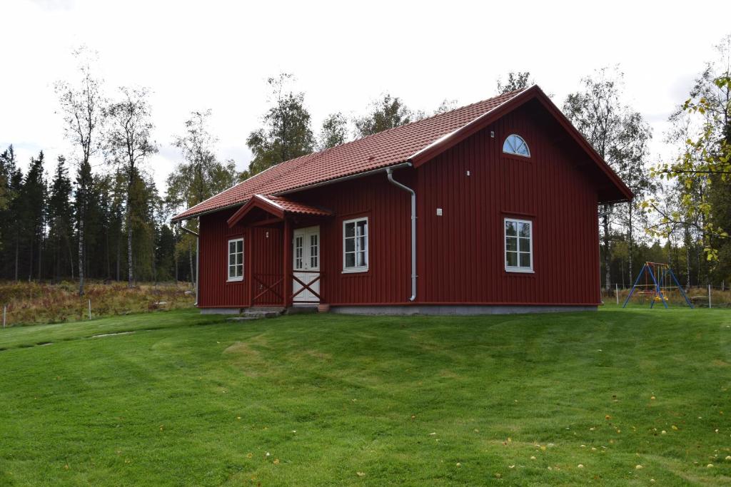 MarieholmKronobo的前面有一个草地庭院的红色谷仓