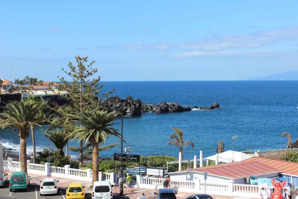 圣地亚哥港Ocean View Apartment at the beach Playa de La Arena的享有海滩和大海的景色,设有汽车