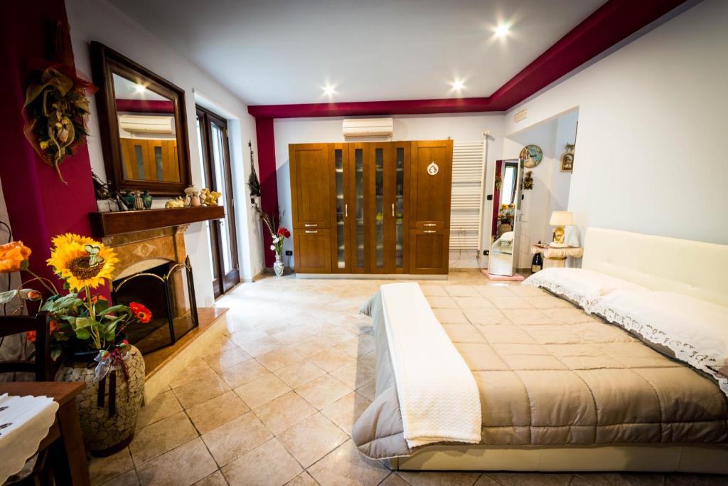 布林迪西Agrumeto degli Angeli的一间卧室设有一张大床和一个壁炉