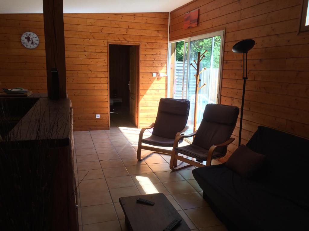 拉卡诺chez steph&aurore的客厅配有两把椅子和一张沙发