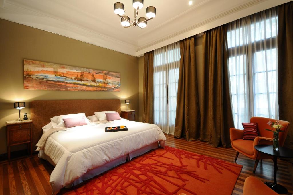 布宜诺斯艾利斯Casa Umare的卧室配有一张白色大床和红色地毯