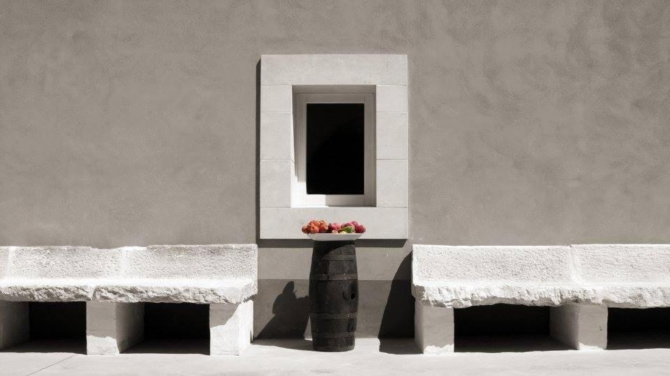 基亚拉蒙泰-古尔菲Terre di Senia的两把长椅,坐在一堵墙上,放着一碗水果