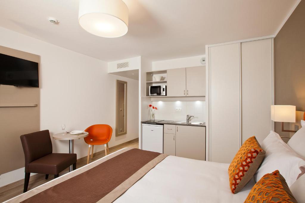 巴黎巴黎罗莎帕克斯公寓式酒店的酒店客房带一张床和一个厨房