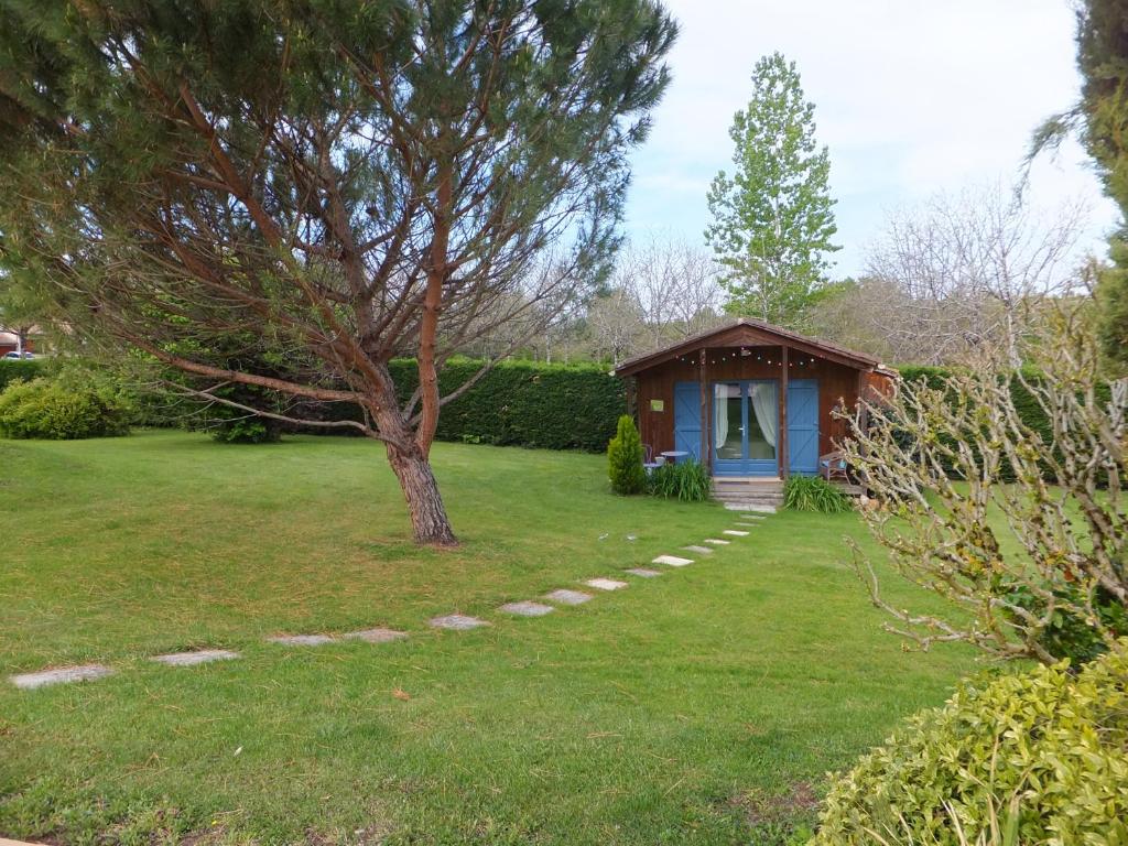 Vergt-de-BironLe Chalet Bleu的一座小房子,在院子里,有树