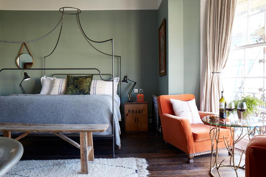 布莱顿霍夫布莱顿艺术家驻地公寓的一间卧室配有一张床和一张橙色椅子