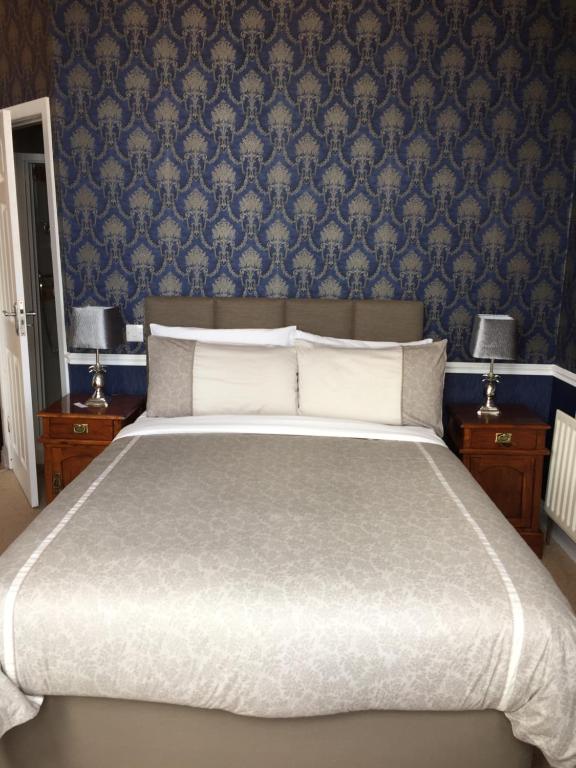 波特拉什奥尔巴尼旅馆的一间卧室配有一张带蓝色壁纸的大床