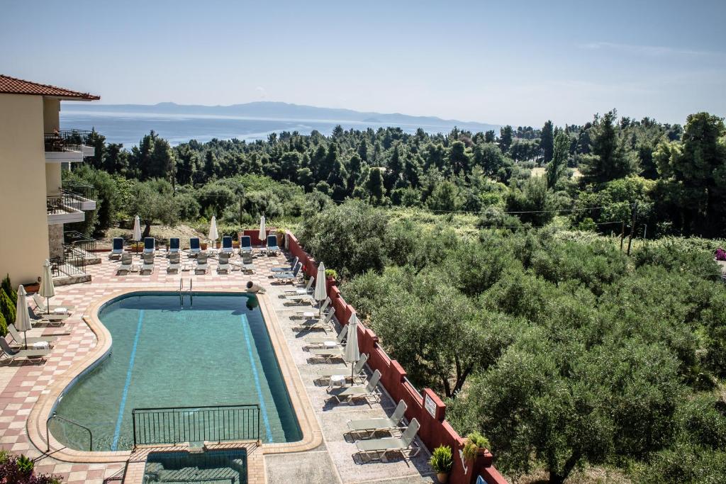 克里皮吉Hotel Ilios的一个带椅子和树木的度假村游泳池