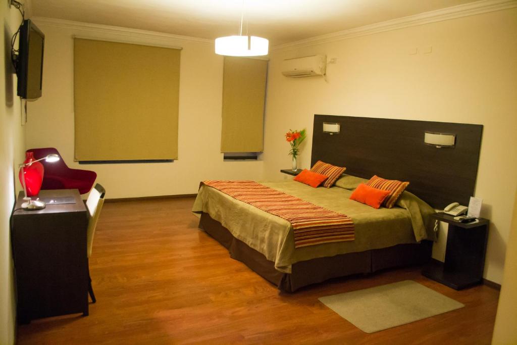 萨尔塔拉斯维加斯酒店的一间卧室配有一张带橙色枕头的大床