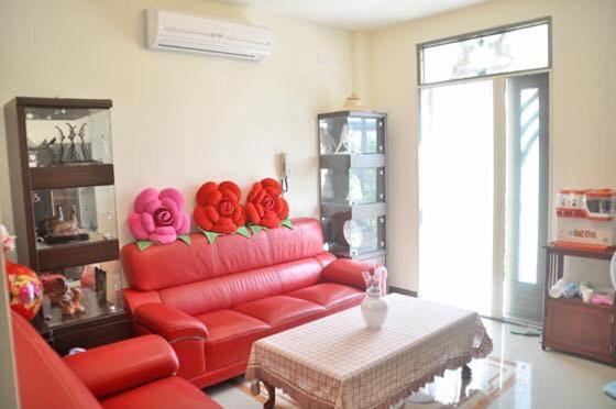 冬山乡宜蘭樂活小屋的客厅配有红色的沙发和桌子