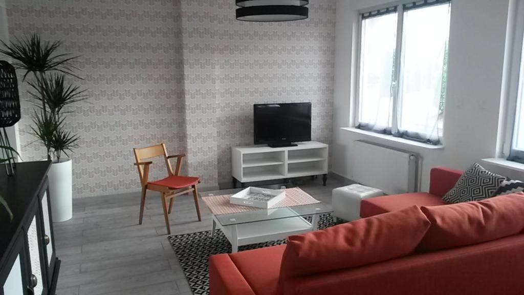 VerlinghemPause Messines Chez Thérèse的客厅配有红色沙发和电视