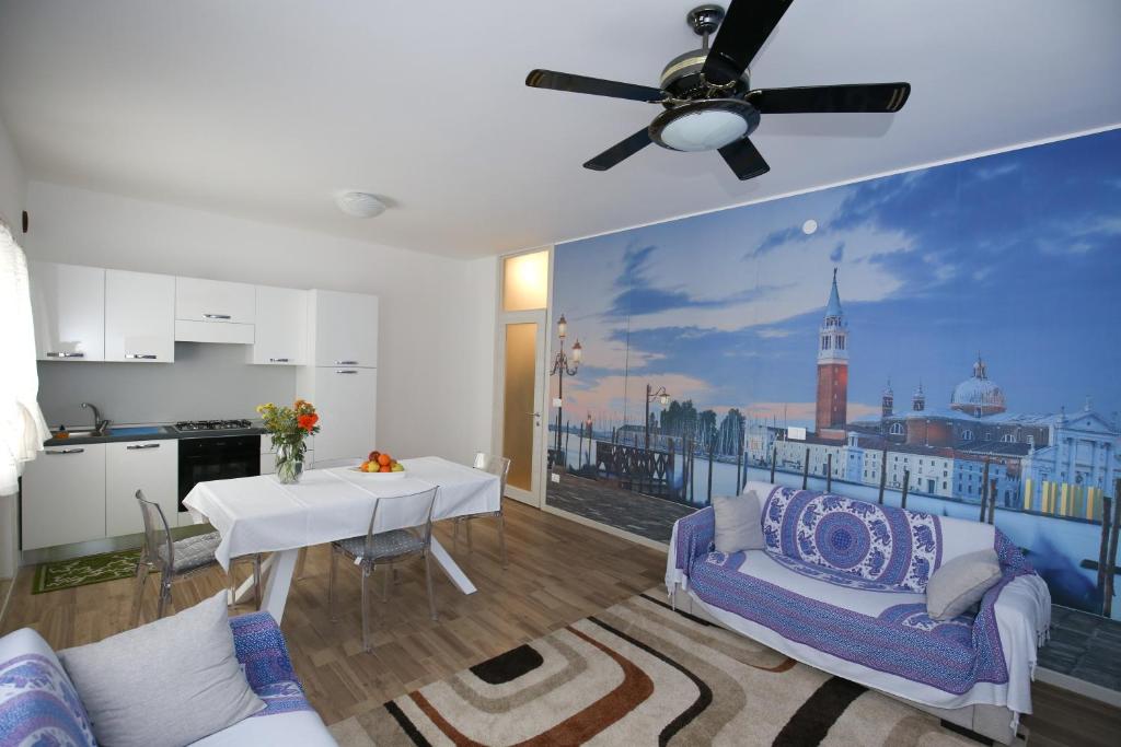 马格拉威尼斯阁楼公寓的客厅配有桌子和吊扇