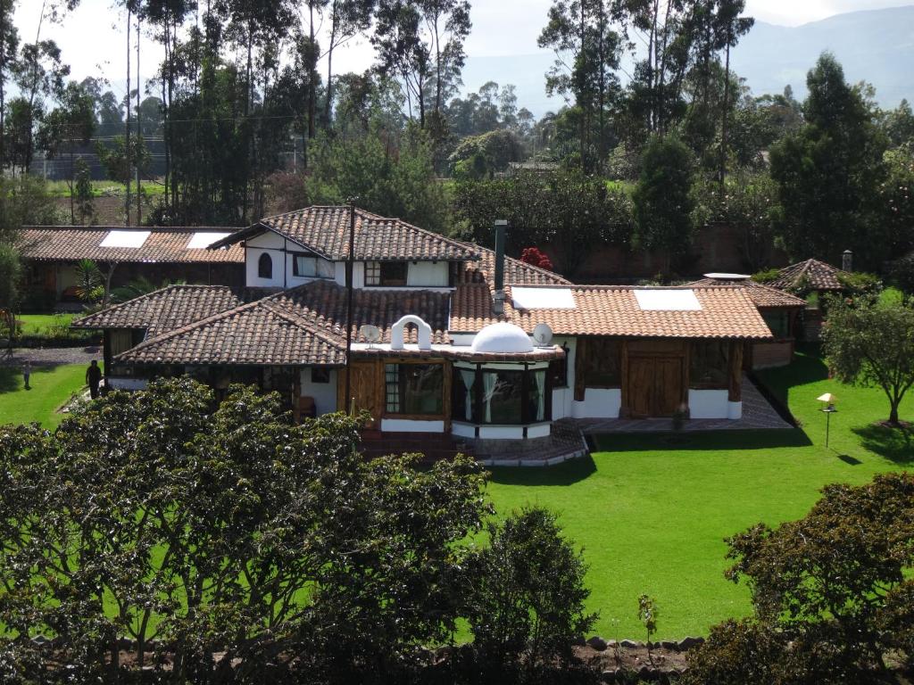 Puembo赞桑特山林小屋的享有绿色庭院房屋的空中景致