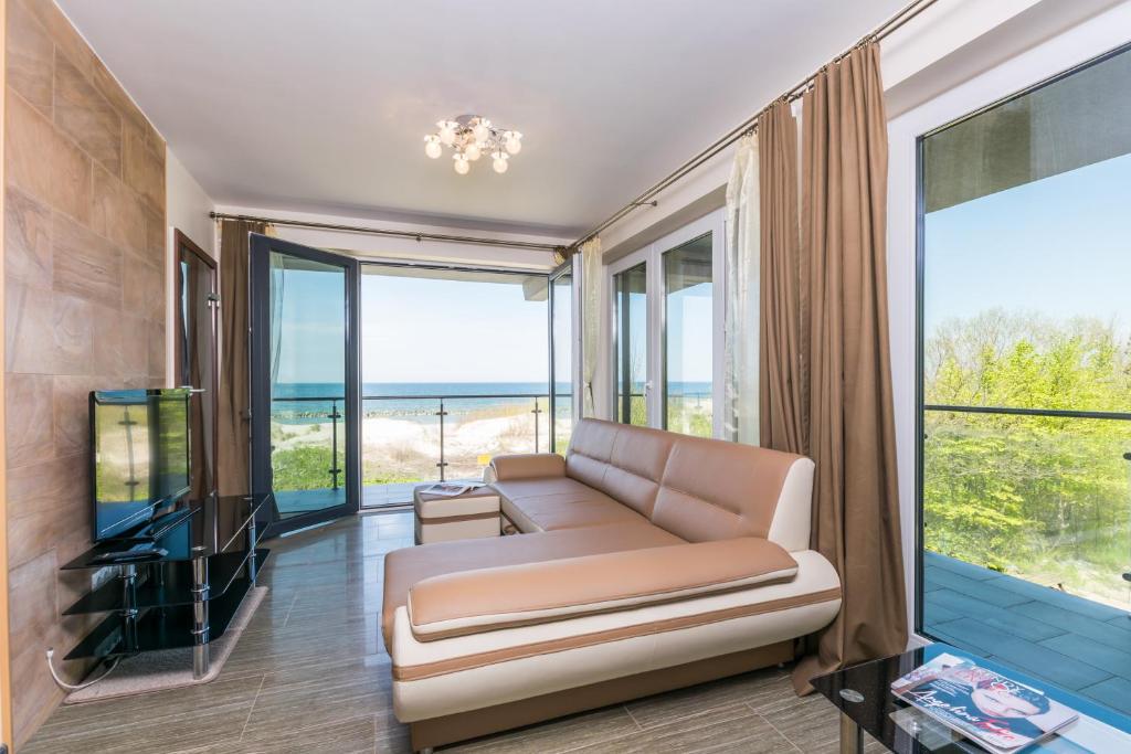 达洛科Apartamenty Amon z widokiem na morze的带沙发和电视的客厅