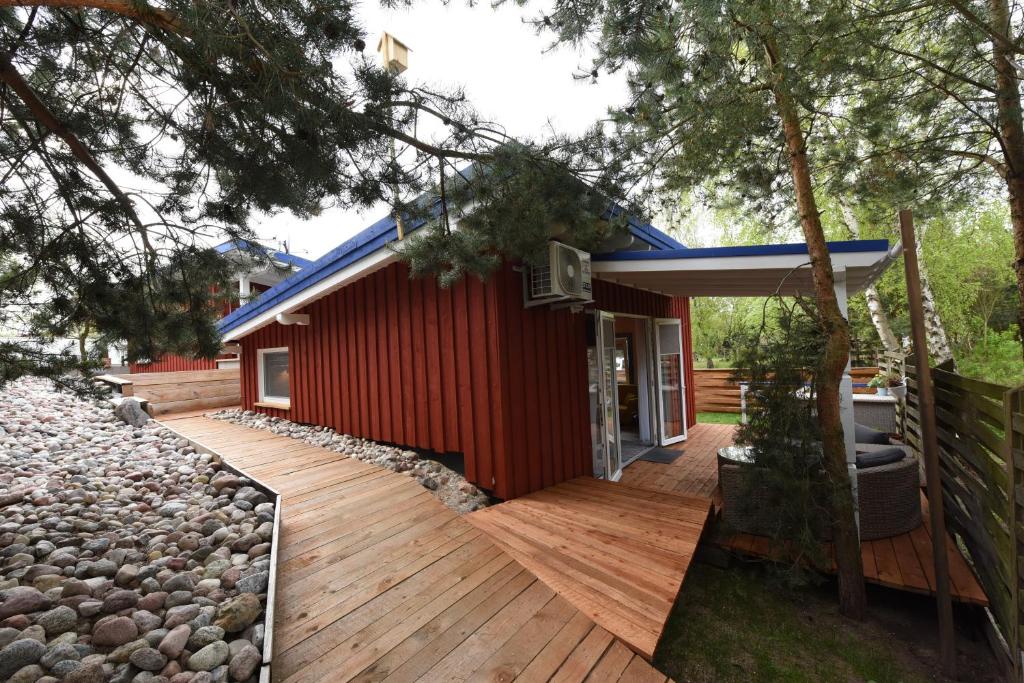 克莱佩达Namelis poilsiui prie jūros的红色的房子,设有木甲板