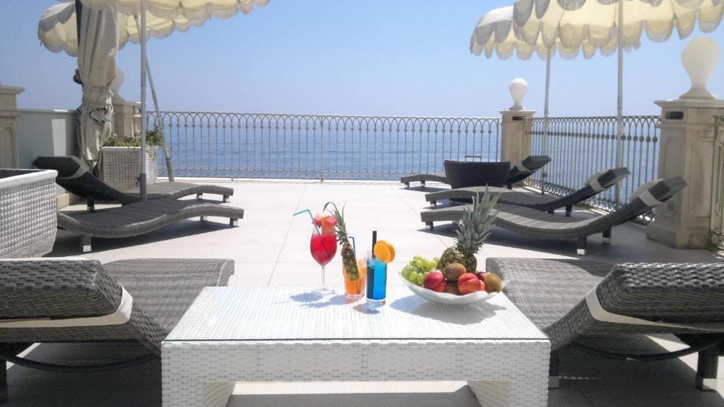 阿奇雷亚莱B&B Acireale - Il Cavalluccio Marino Fronte Mare的露台上的一张桌子和一碗水果