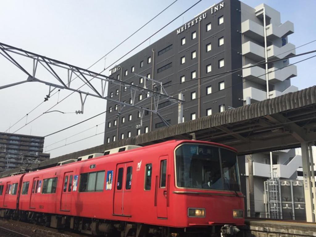 半田名铁赤塔半田市站前酒店的红色的火车正驶入火车站