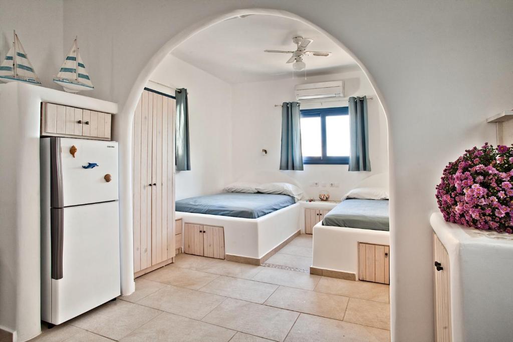 Kyra PanagiaVilla Stamatina的一个带两张床和冰箱的房间的拱门