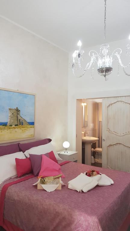 圣伊西多罗Baia Di Torre Squillace的一间卧室配有一张大床和紫色毯子
