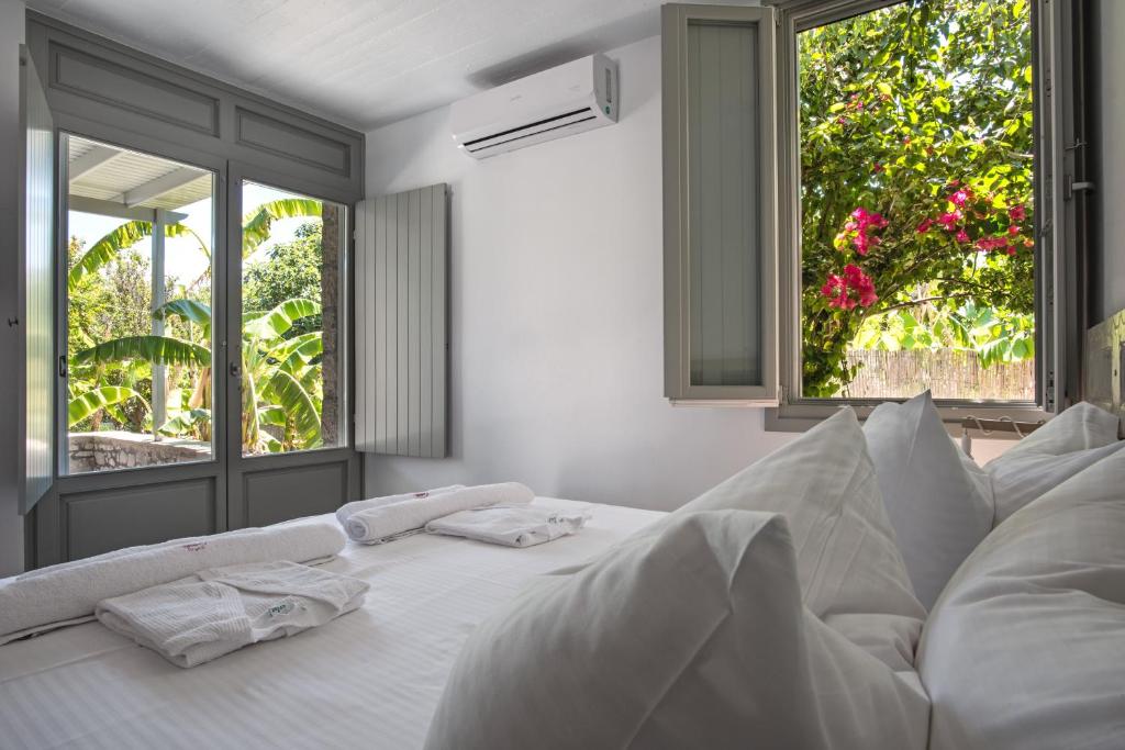 阿达玛斯Melagrana的配有白色枕头的白色床和2个窗户。