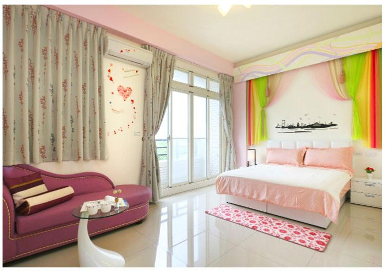 礁溪宏来民宿 的一间卧室配有粉红色的床和紫色的沙发
