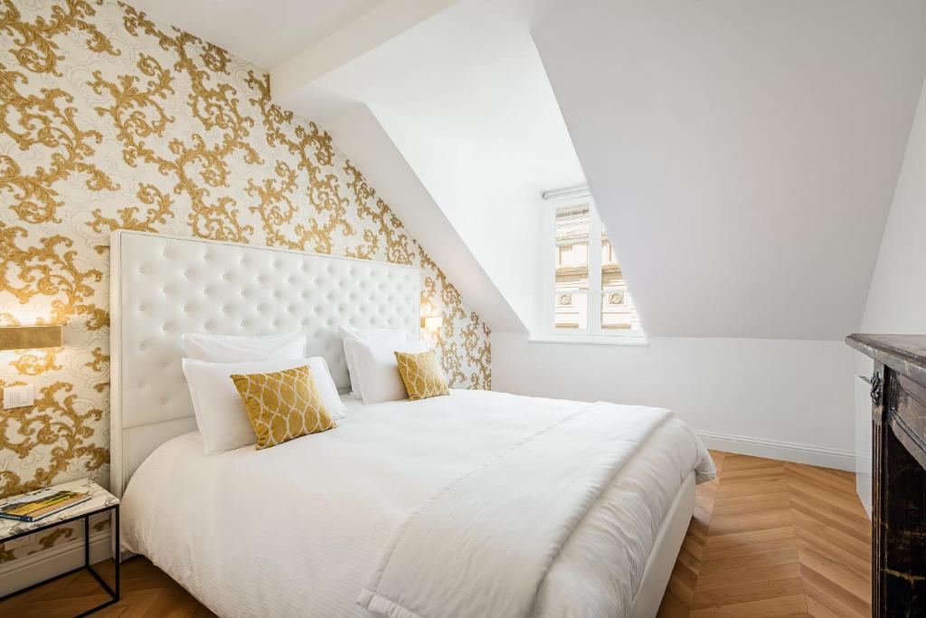 凡尔赛乐斯迪莫赛丽瓦赛奥皮迪度公寓的卧室配有带金色壁纸的大型白色床