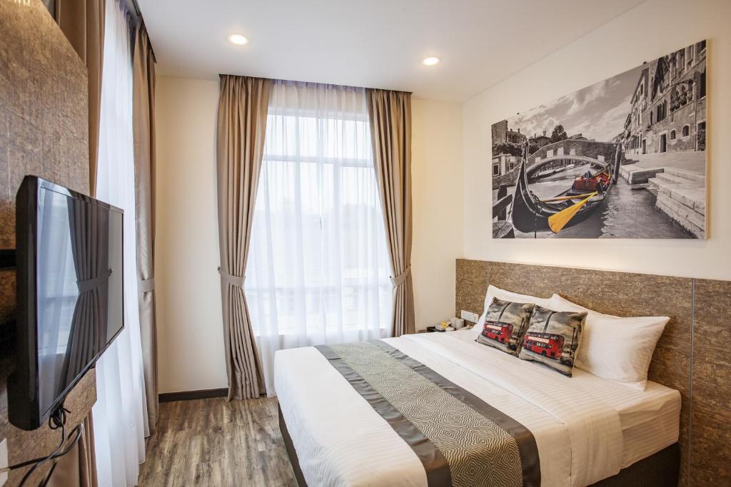 努沙再也自然酒店 的一间卧室设有一张床、一台电视和一个窗口。