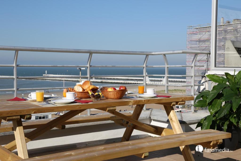 尼乌波特乌林斯皮格尔酒店的阳台上的野餐桌,享有海景