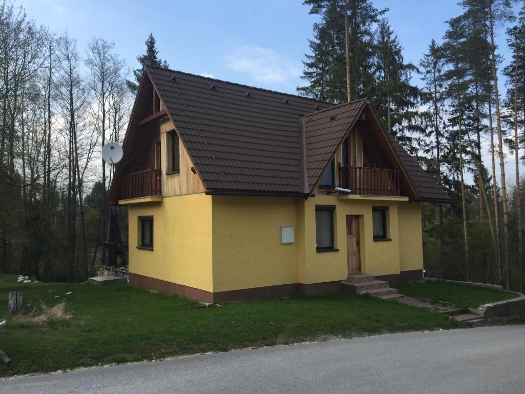 纳梅斯托沃Chata Oravská Priehrada的棕色屋顶的黄色小房子