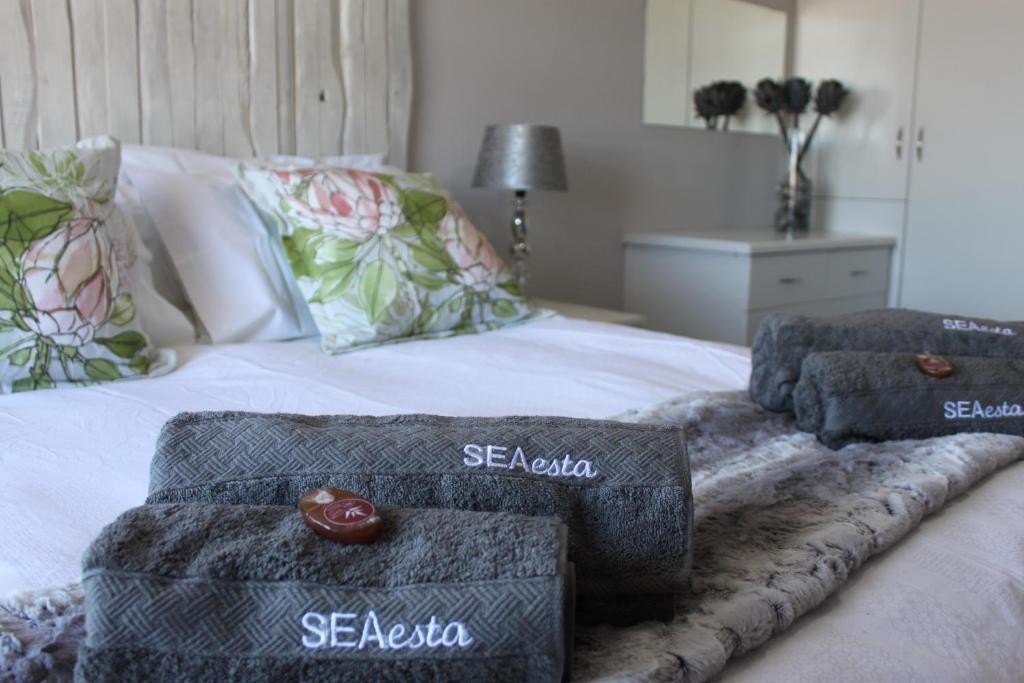 干斯拜SEAesta的一张带两张脚凳和毛巾的床