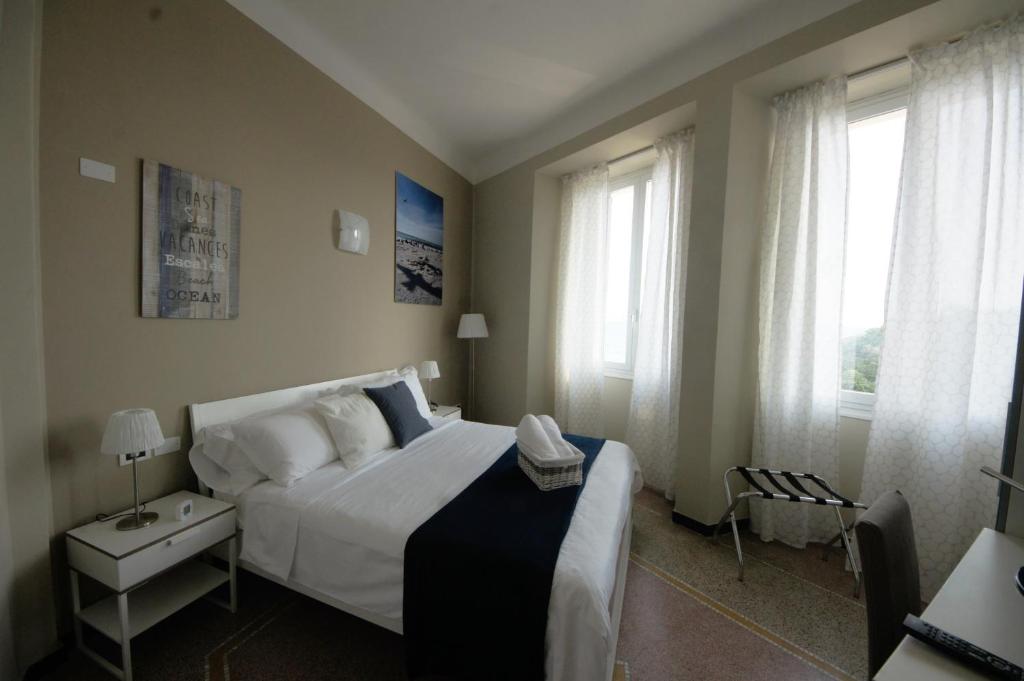 萨沃纳Luna Rooms的卧室设有一张白色大床和两个窗户。