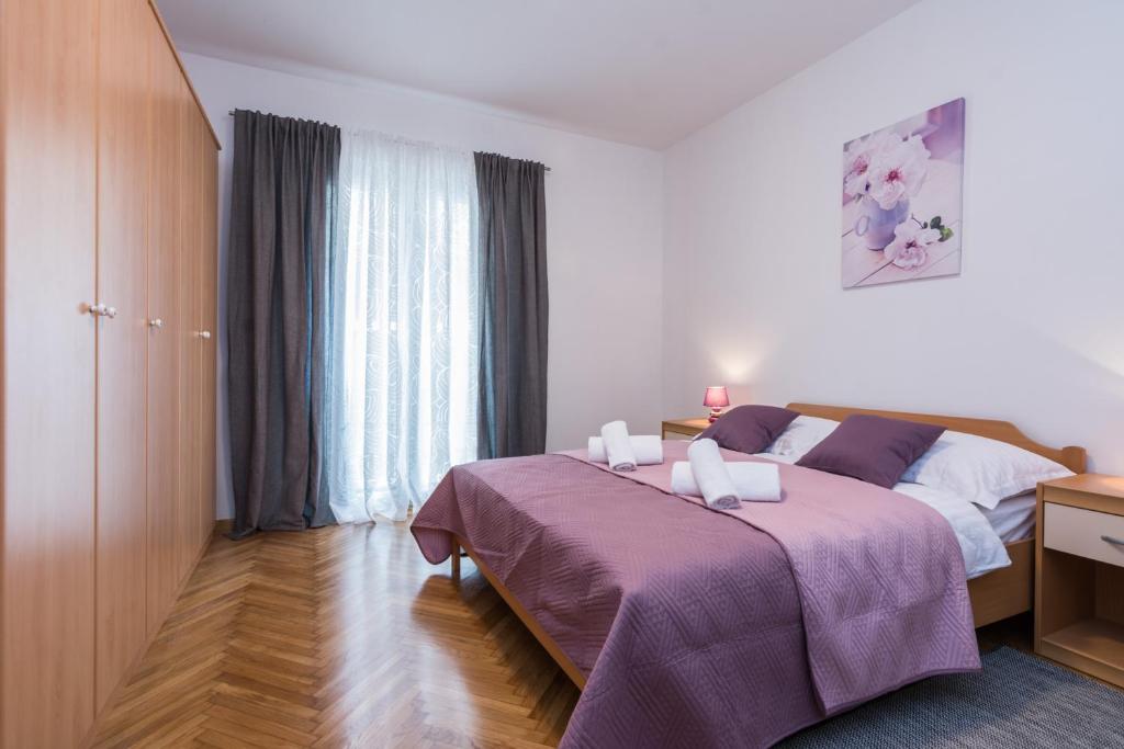 扎达尔Melita Center Apartment的一间卧室配有一张大床和紫色毯子