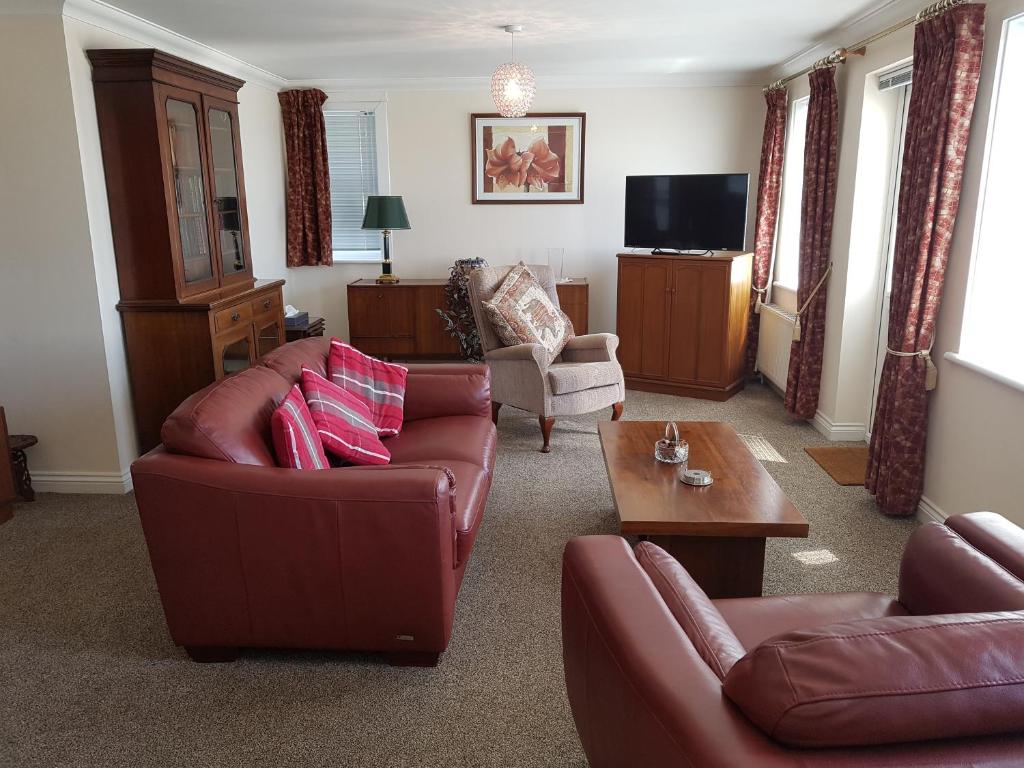 卡斯尔敦1 Derby Court Castletown的客厅配有两张沙发和一台电视机