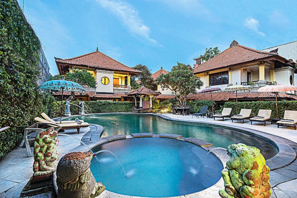 勒吉安Royal Tunjung Hotel & Villa Legian - CHSE Certified的房屋前有游泳池的房子