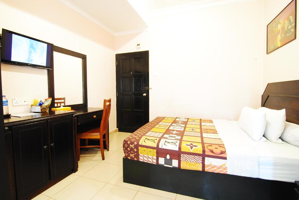 丹戎槟榔全景酒店的一间卧室配有一张床、一张桌子和一台电脑