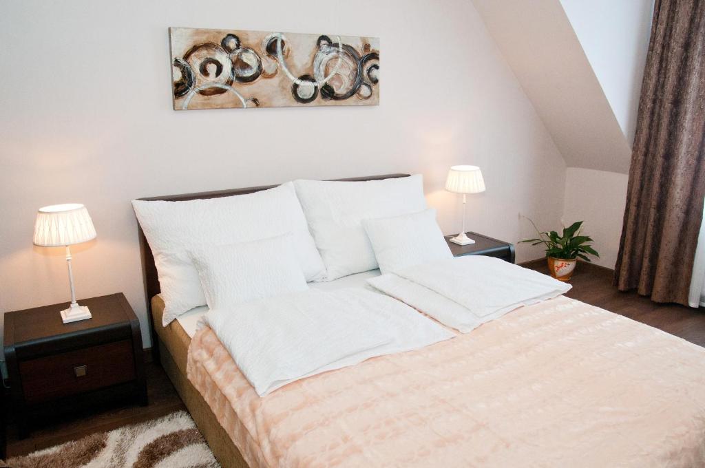 赫维兹Ametiszt Apartman的卧室内的一张带白色床单和枕头的床