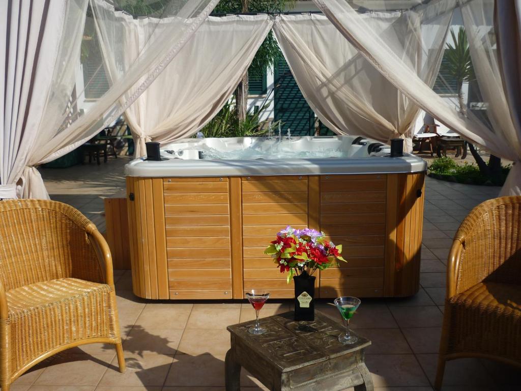 圣多米诺莱万特酒店的庭院内的按摩浴缸,配有两把椅子