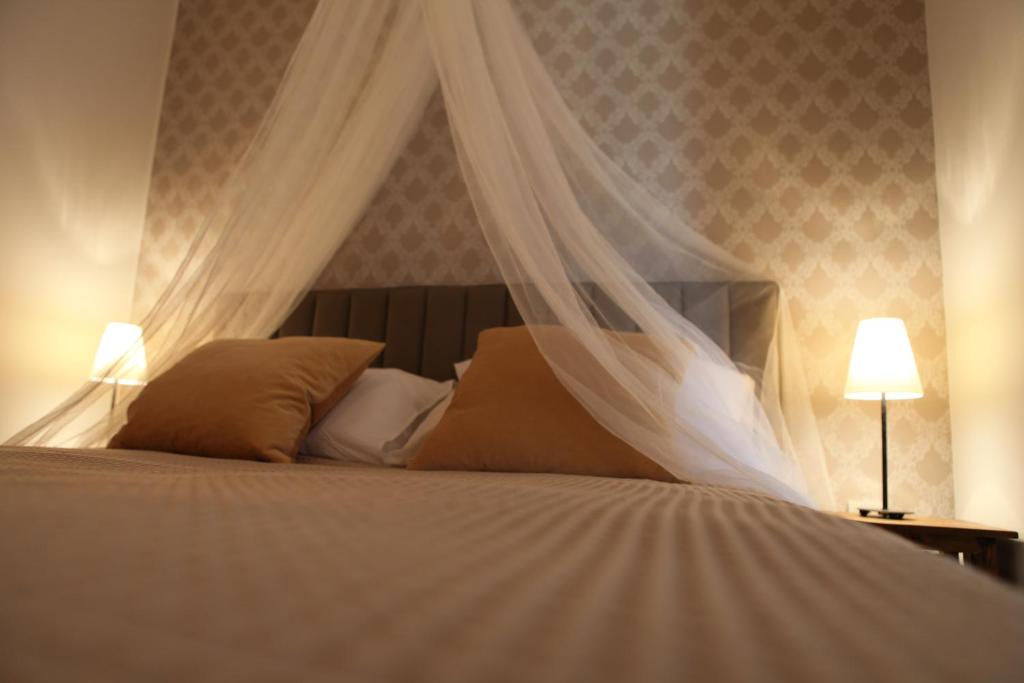 SelineApartment Blue ivy的一间卧室配有一张带天蓬和两盏灯的床。