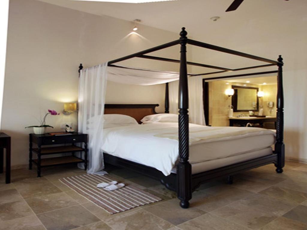 圣斐利-银港卡萨殖民海岸温泉酒店的一间卧室配有天蓬床和镜子