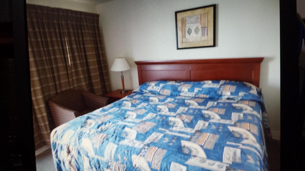 尼亚加拉瀑布艾利威特鲁姆斯星星汽车旅馆的一间卧室配有一张带蓝色和白色被子的床